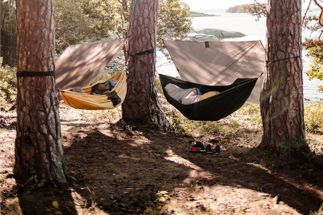 Kuvituskuva Ruohonjuuren Yö riippumatossa blogista. Kuvassa kaksi rippumattoa metsässä puuhun kiinnitettyinä.