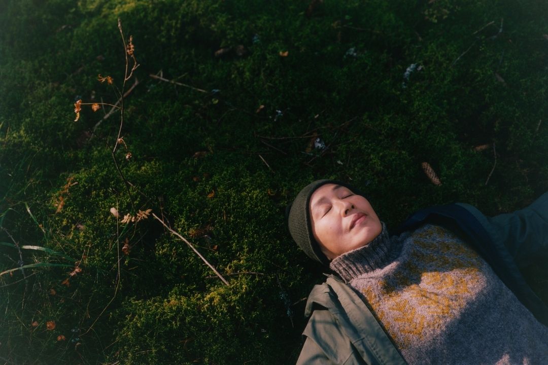 Ihminen makaa sammaleen päällä